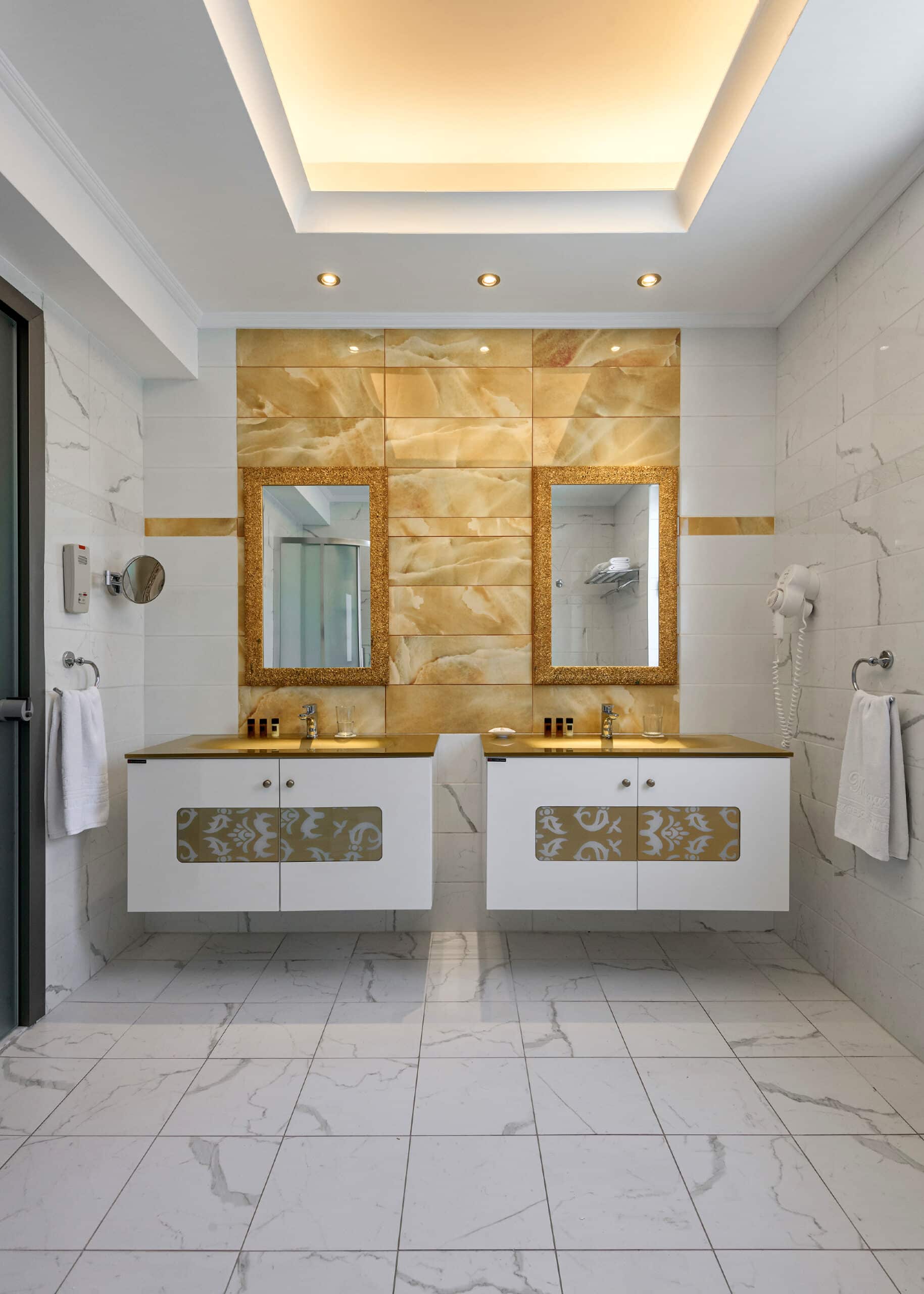 http://Salle%20de%20bain%20luxueuse%20avec%20deux%20lavabos,%20murs%20ornés%20de%20carreaux%20dorés.